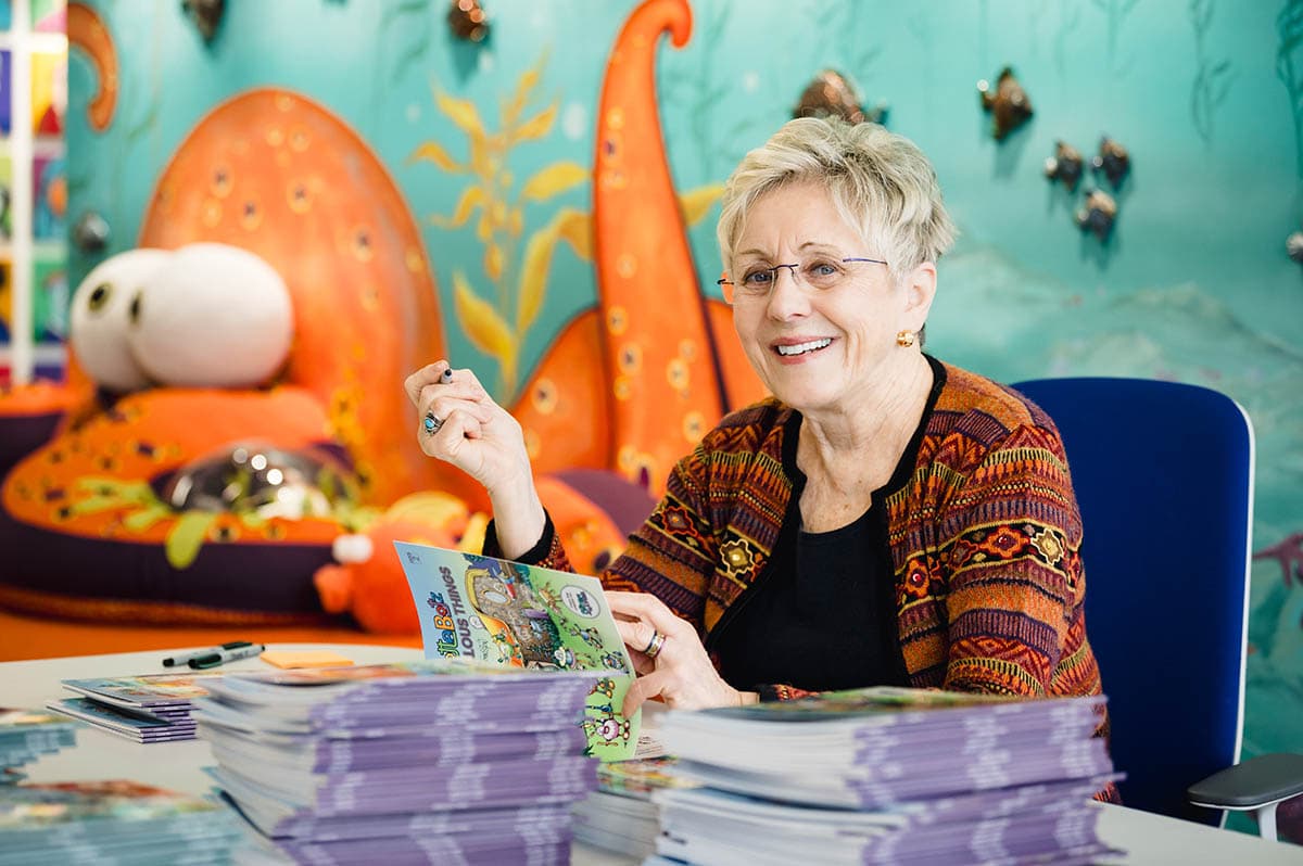 Lynn Johnston in her studio with a pile of Alottabotz® books.
